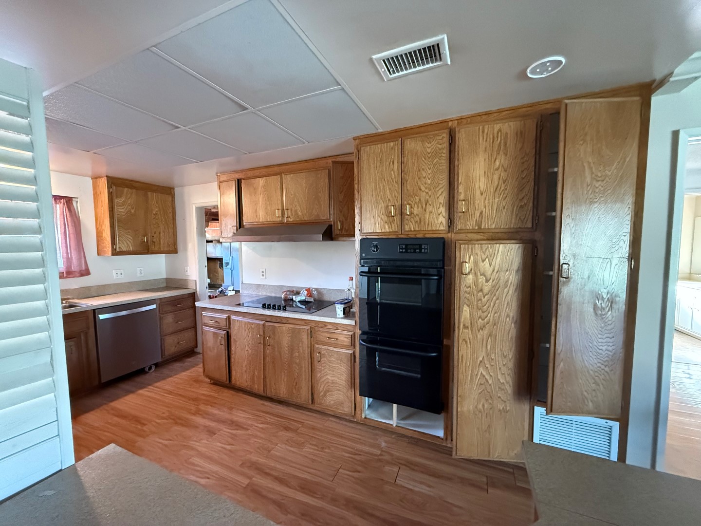 Kitchen before renovation — original oak cabinetry and drop ceiling