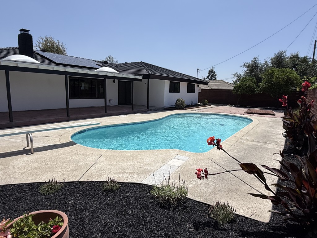 Backyard wide view with pool and horizontal-slat privacy fence